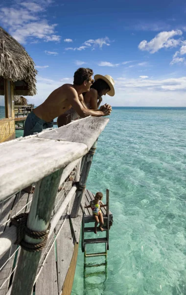 A couple enjoying the view from their bungalow on stilts in Taha'a©_Grégoire Le Bacon